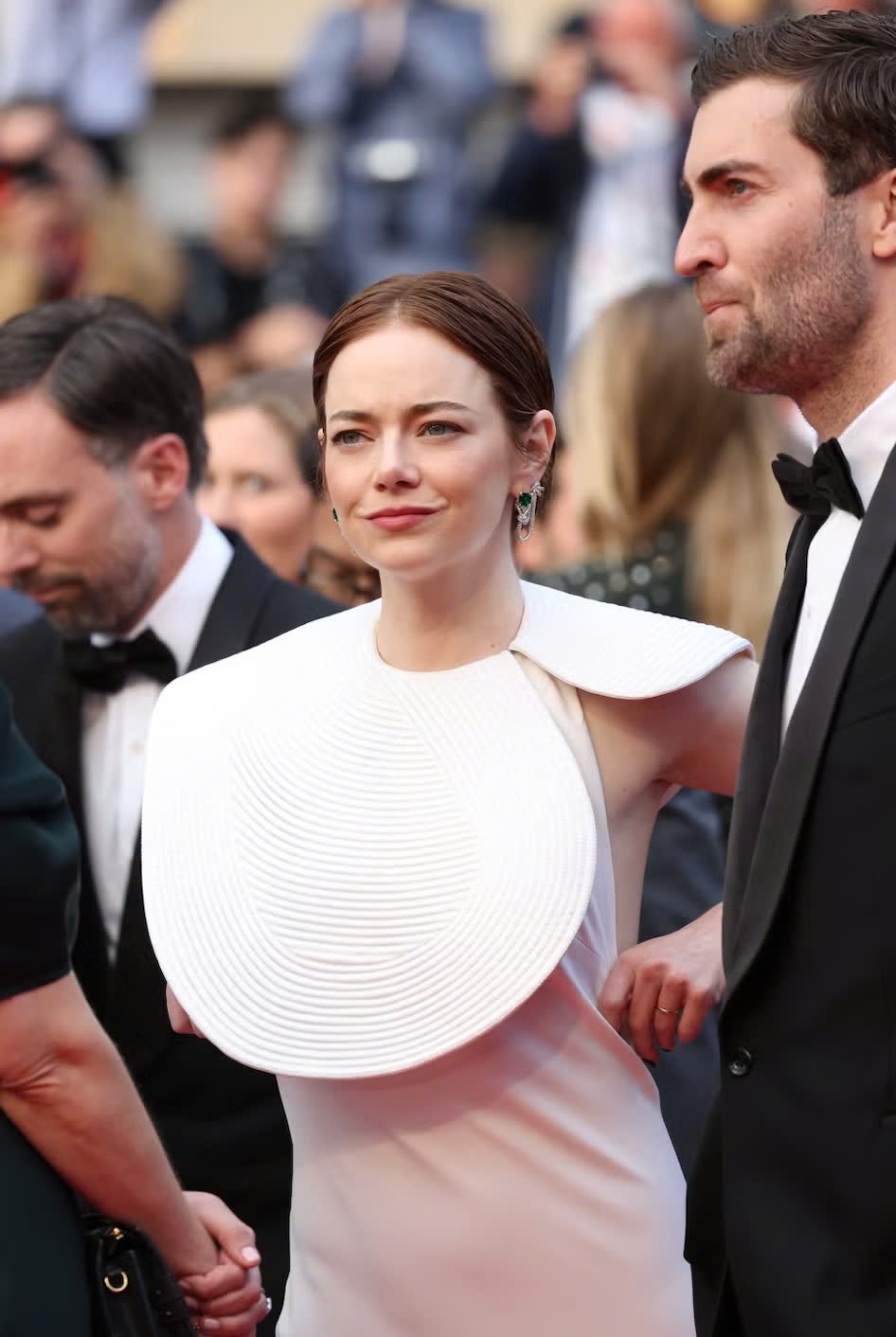 Emma Stone sánh bước trên thảm đỏ cùng Dave McCary. Nữ diễn viên mặc váy màu trắng của Louis Vuitton, có điểm nhấn ở phần thân trên, trong khi Dave McCar chọn bộ vest đen cổ điển.