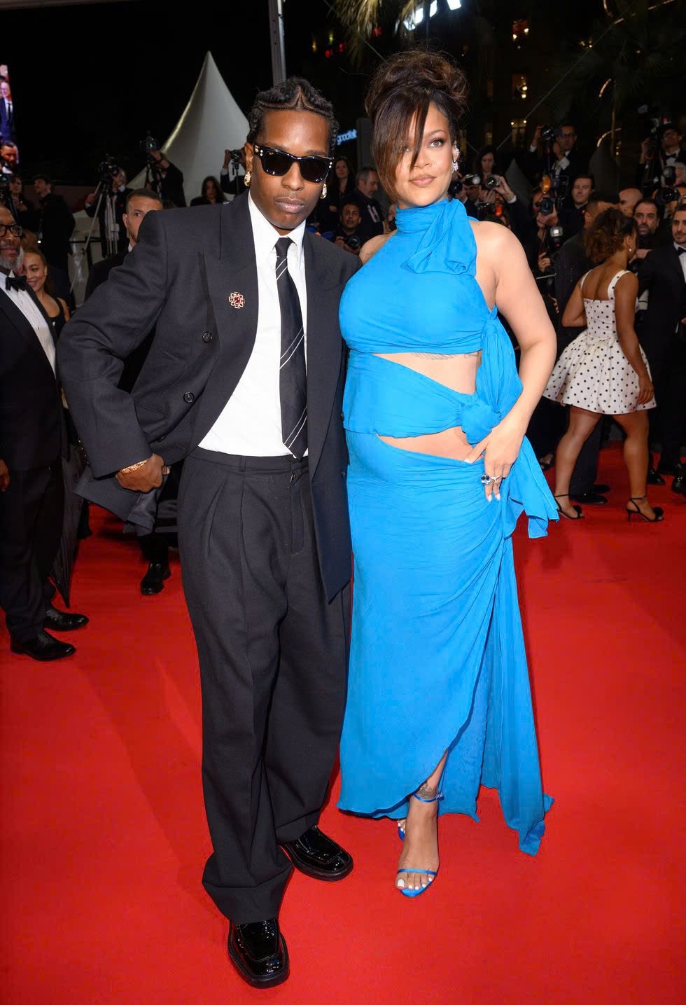 Trên thảm đỏ Liên hoan phim Cannes 2025, ca sĩ Rihanna xuất hiện ấn tượng trong bộ đầm bó màu xanh, khoe bụng bầu lớn khi đang mang thai con thứ ba. Nữ ca sĩ sánh đôi cùng bạn trai A$AP Rocky, người đóng vai chính trong bộ phim mới của đạo diễn Spike Lee là "Highest 2 Lowest".