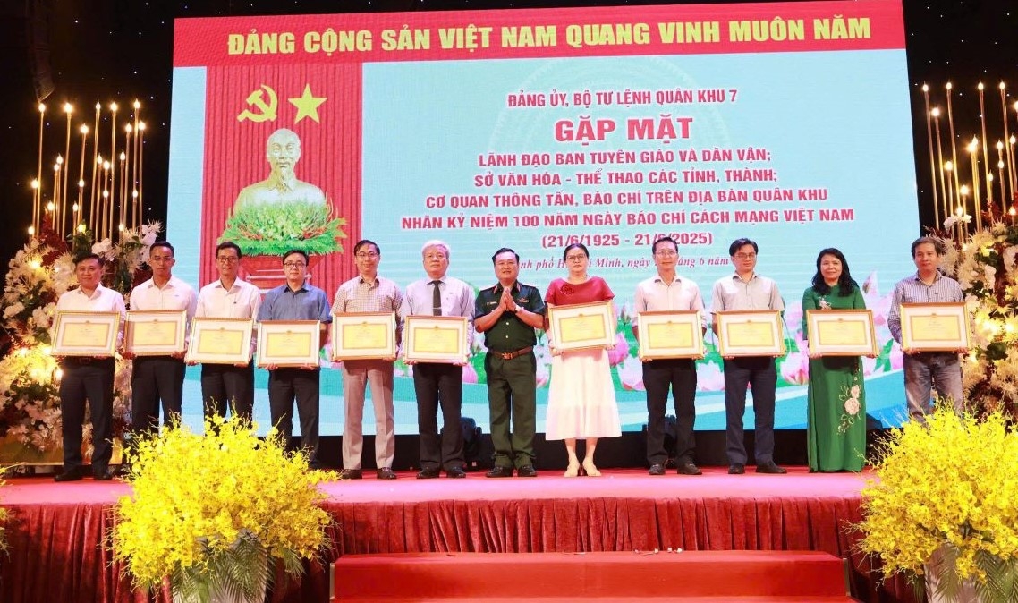Bà Cao Thị Thoa, Phó Giám đốc CQTT Đài Tiếng nói Việt Nam tại TP.HCM (áo dài) nhận Bằng khen của Bộ Tư lệnh Quân khu 7 dành cho các tập thể