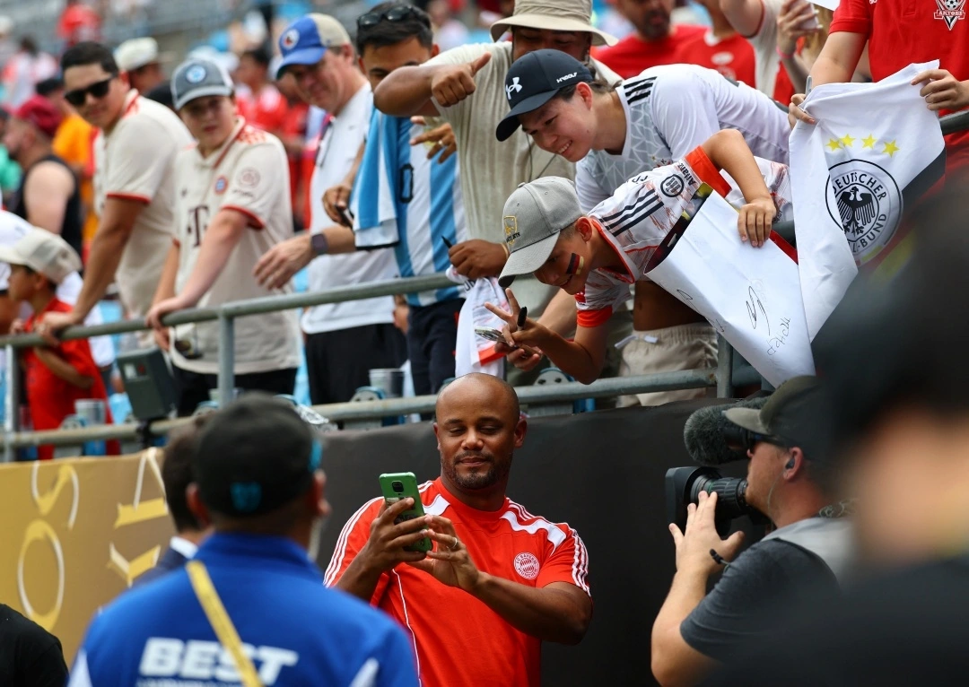HLV Vincent Kompany chụp hình cùng người hâm mộ Bayern (Ảnh: Reuters)