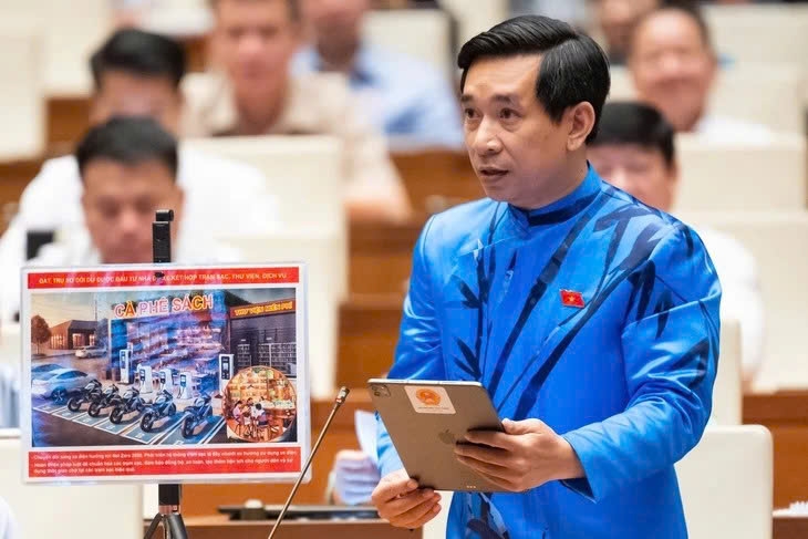 Đại biểu Nguyễn Văn Cảnh cùng với hình ảnh ông mang đến hội trường để minh họa cho giải pháp giảm ùn tắc giao thông, tại phiên thảo luận về kinh tế - xã hội ngày 18/6. 