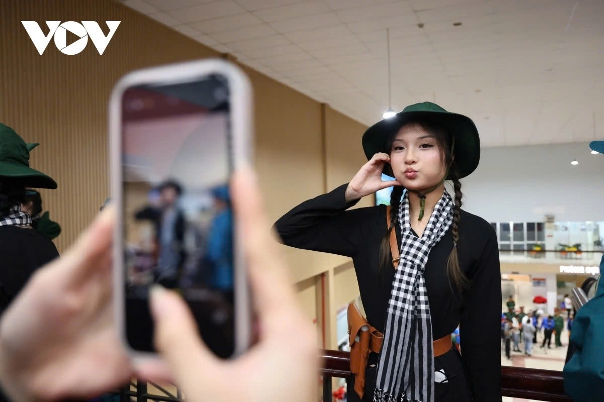 A playful young soldier strikes a pose for a check-in photo just before the train departs.