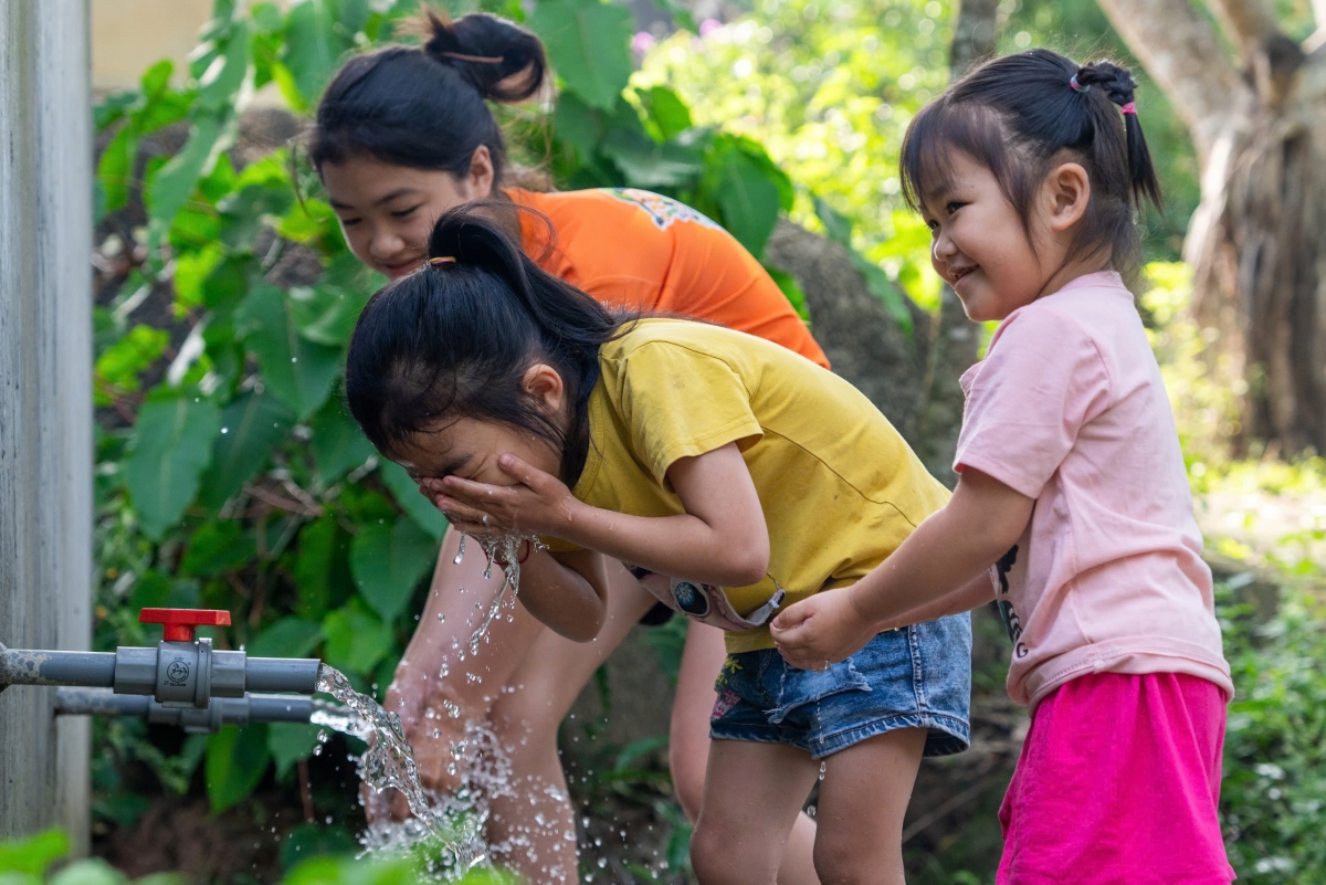 Những đứa trẻ ở Khe Sơn vui tươi bên dòng nước mát từ trên núi về. Ảnh: Nguyễn Đạo.