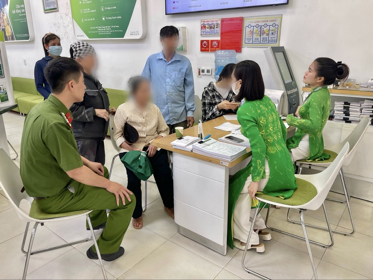Cụ P.T.N. được cán bộ công an và nhân viên ngân hàng giải thích về hành vi lừa đảo của các đối tượng. (Ảnh: Công an Hải Dương)