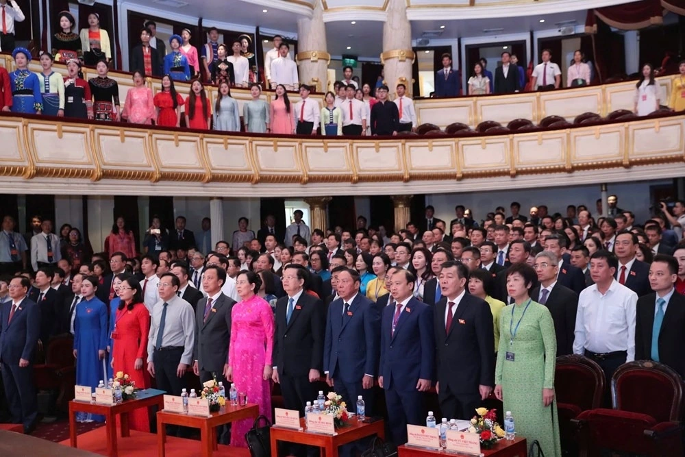 Các đại biểu tham dự Đại hội thực hiện nghi thức chào cờ, hát Quốc ca, Quốc tế ca.