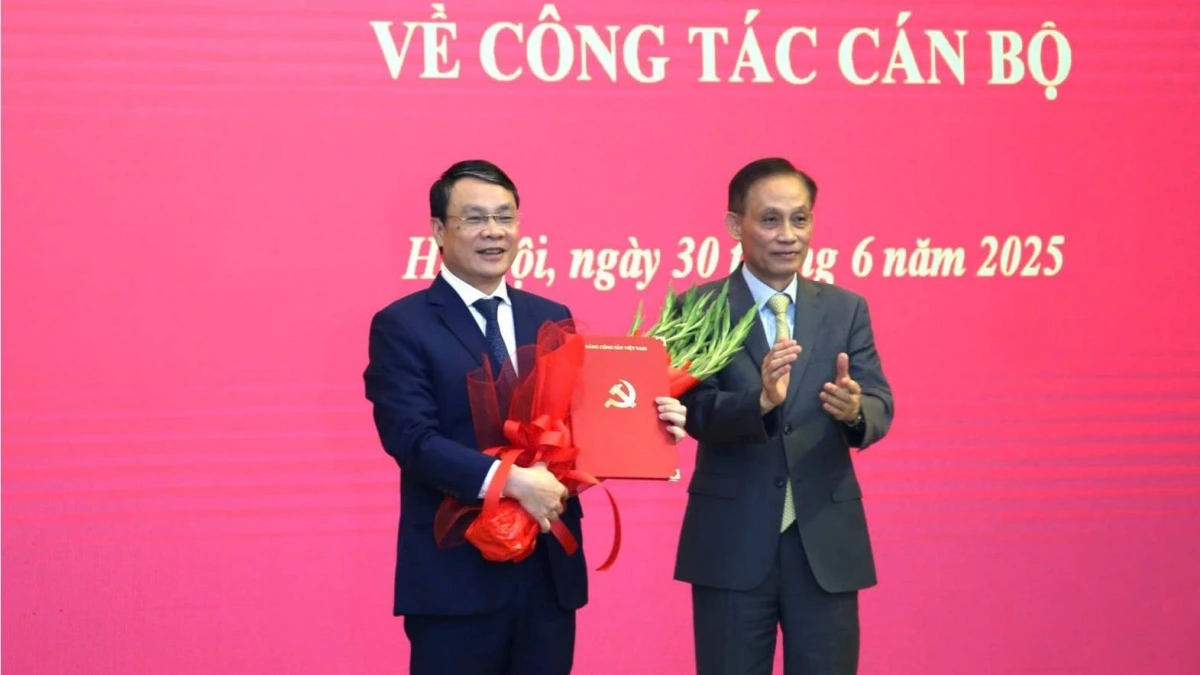 Chánh Văn phòng Trung ương Đảng Lê Hoài Trung trao quyết định và tặng hoa chúc mừng ông Đặng Khánh Toàn. ảnh: dangcongsan.vn
