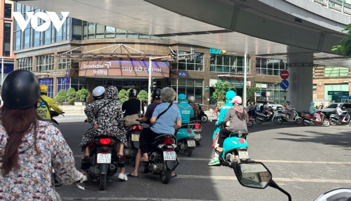 Motorbike drivers try to find shade to keep themselves cool.