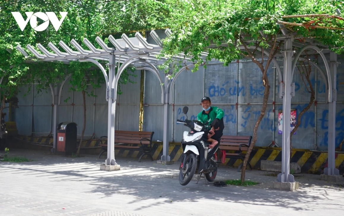 A Xe ôm (motorbike driver) seeks shade in an effort to keep himself cool amid the ongoing heat wave.