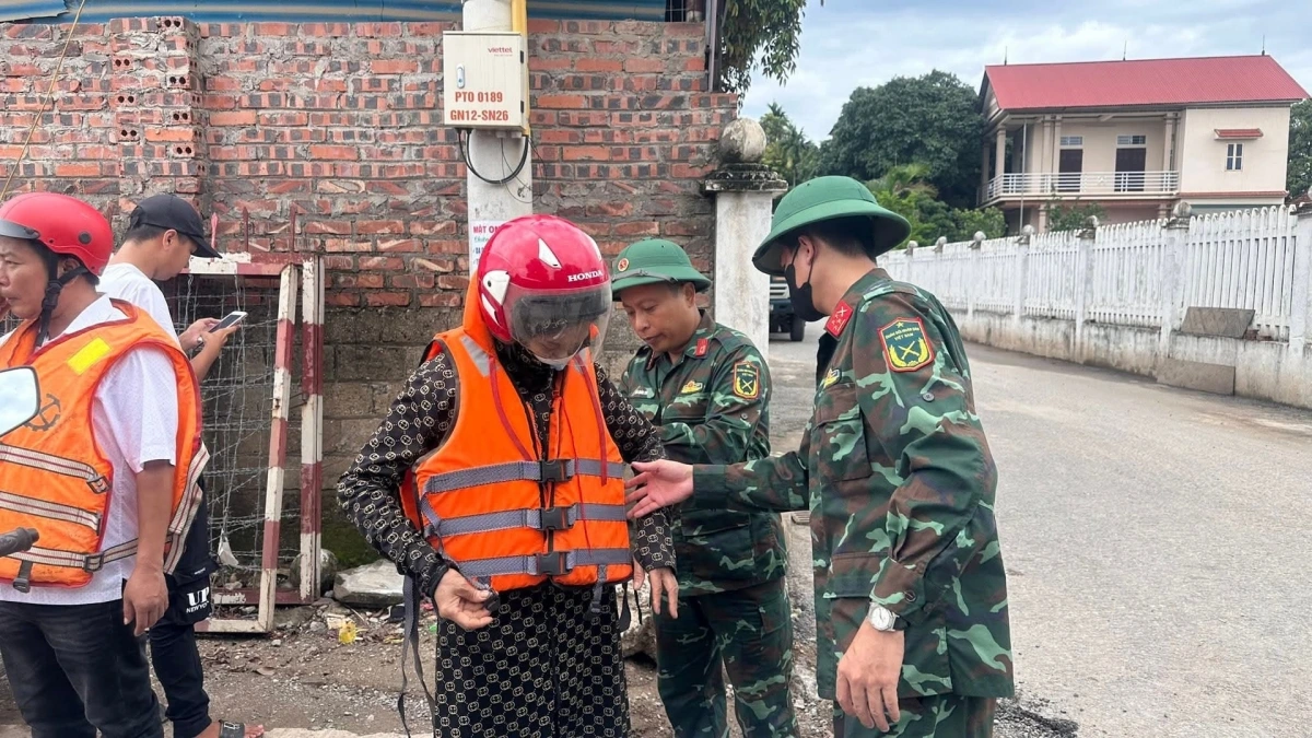 Các chiến sỹ hướng dẫn người dân mặc áo phao đúng cách.