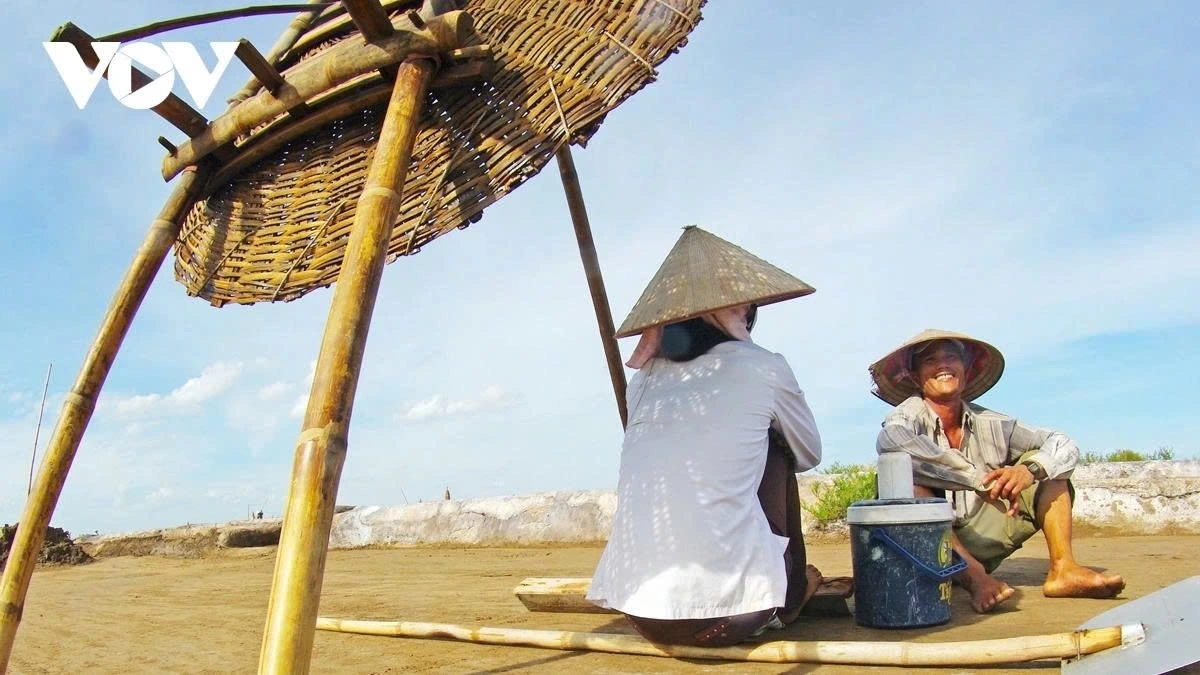 Amid the hard work, moments of rest offer a glimpse into the camaraderie of the salt workers, who smile and chat while waiting for the salt to form.
