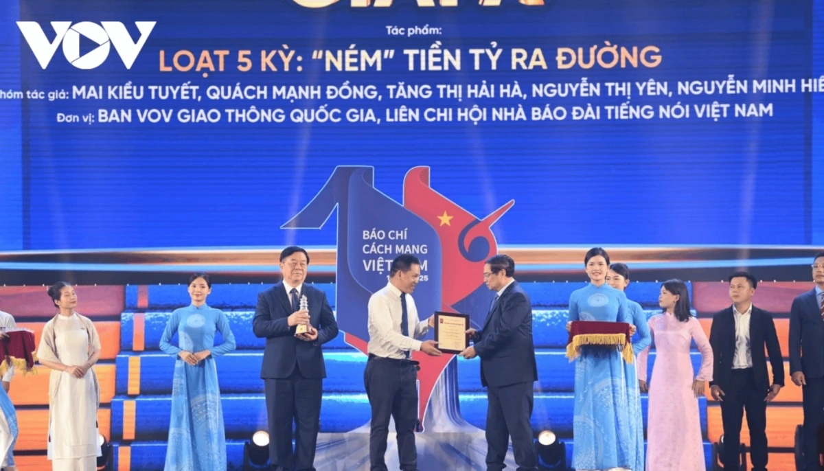  Prime Minister Pham Minh Chinh presents a first prize to the author group from VOV National Traffic chanel for their five-part investigative series titled “Throwing Billions onto the Road.”