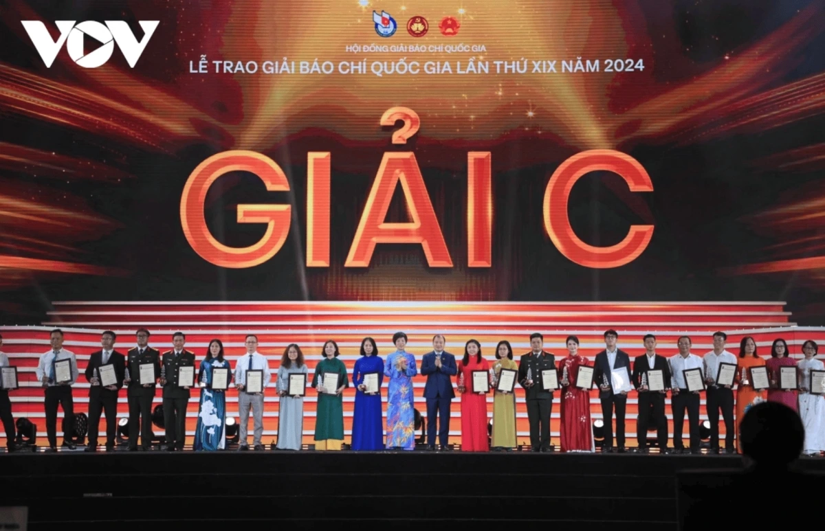   Le Hai Binh, Alternate Member of the Party Central Committee and Deputy Minister of Culture, Sports and Tourism, and Vu Viet Trang, General Director of the Vietnam News Agency, present third prizes to the winning authors and groups.