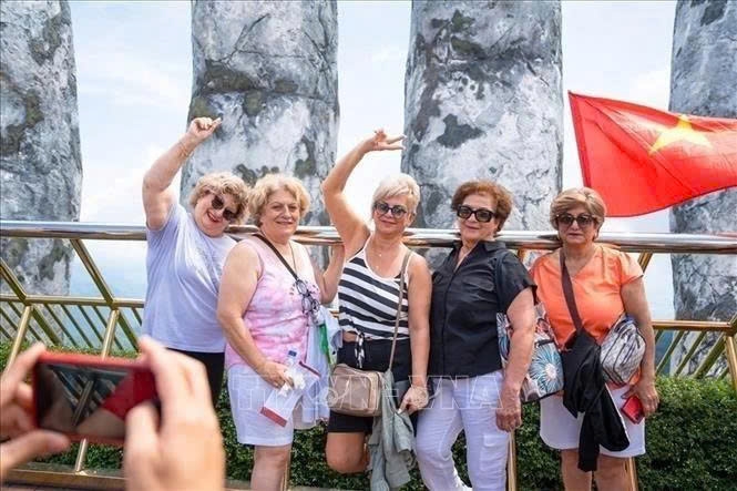 Foreign tourists enjoy checking in on the Golden Bridge in the Sun World Ba Na Hills complex in the central city of Da Nang.