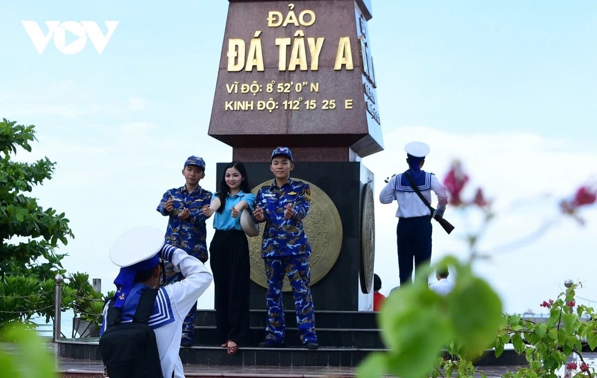 While one soldier stands guard in full concentration, his comrades meet with visitors from the mainland.