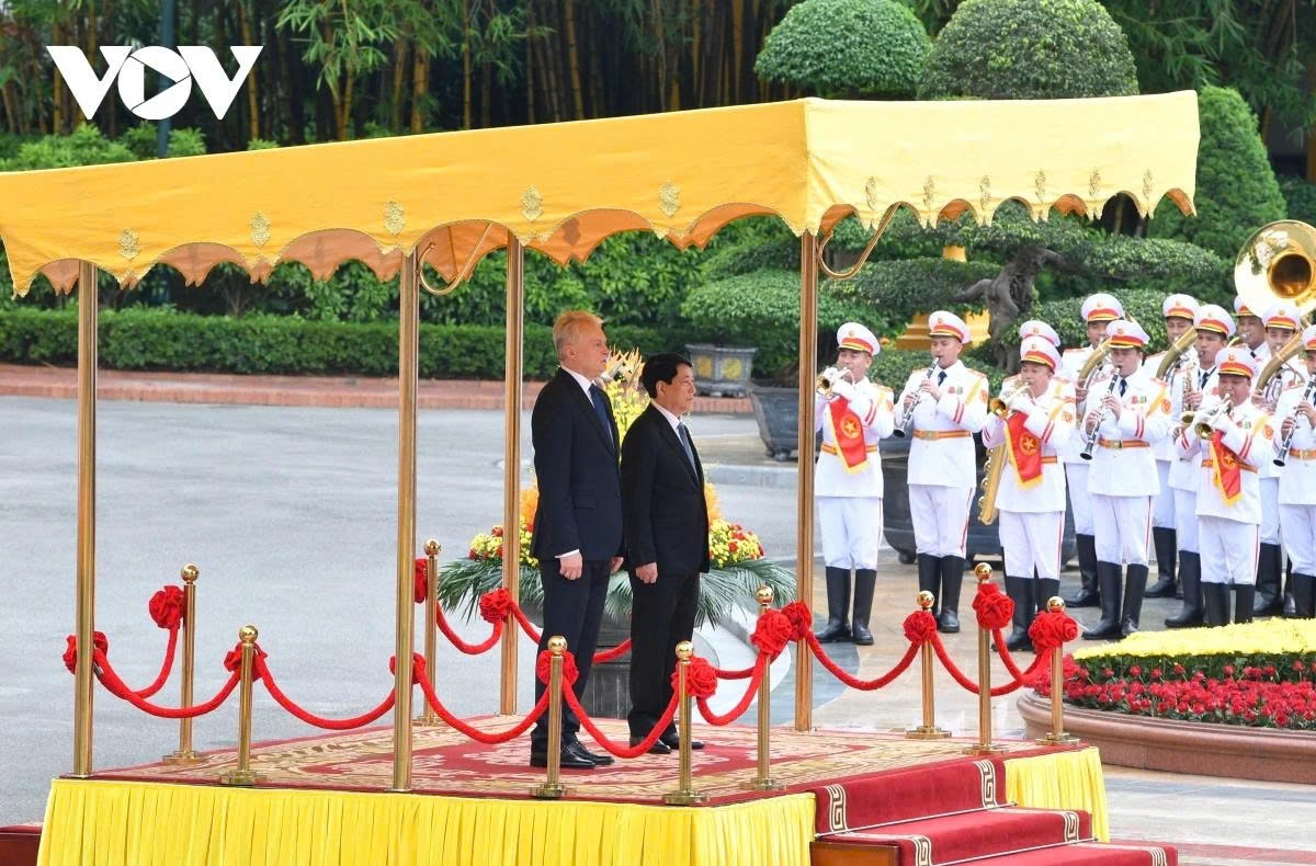 The two leaders stand on the podium while the military band plays the national anthems of both countries.