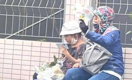 Người mẹ cùng con gái nhỏ vui vẻ ngồi đợi nam thí sinh thi xong để cùng về.