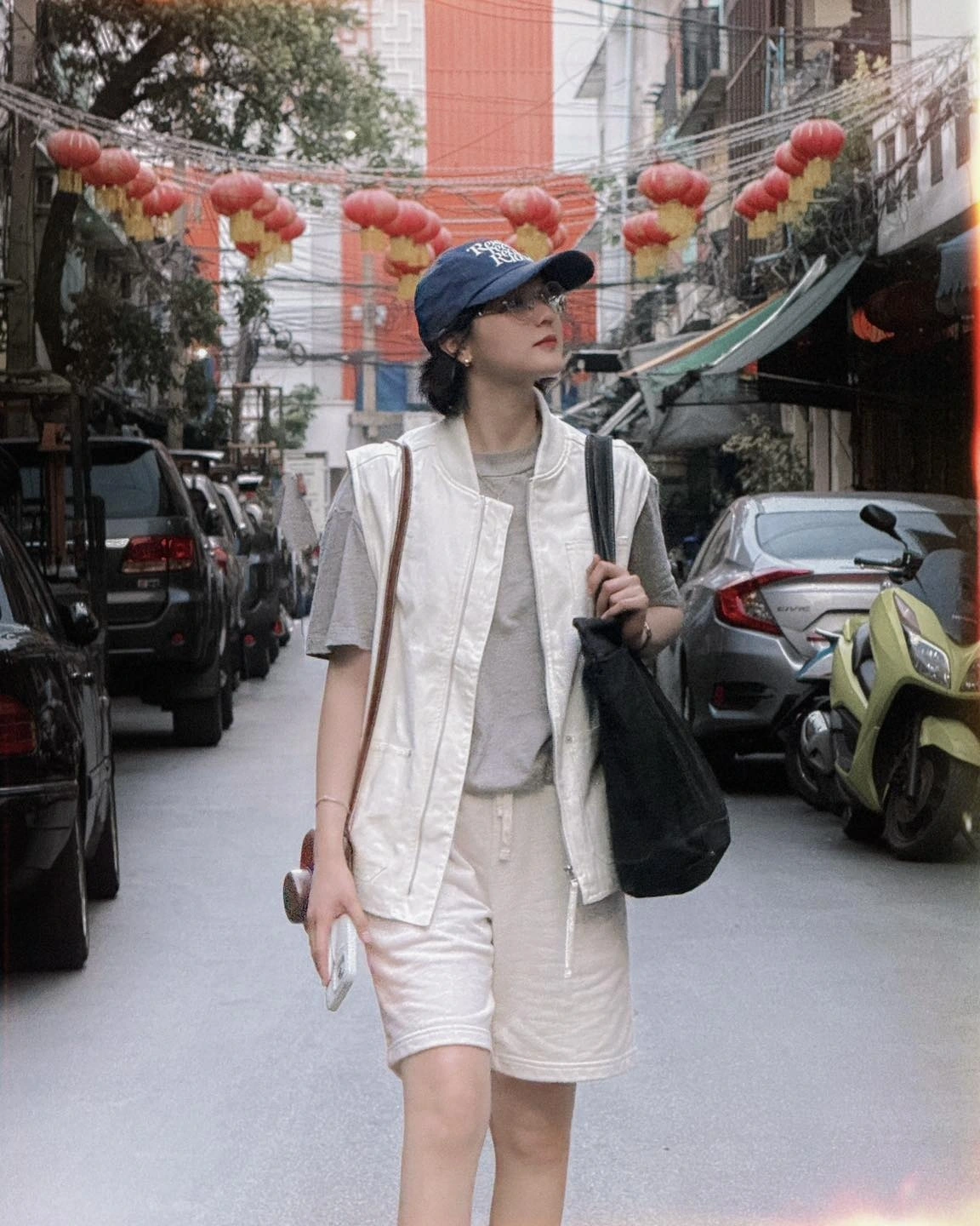 Điểm dễ nhận thấy trong gu thời trang của Hải Tú là sự tối giản. Cô thường chọn những gam màu trung tính như trắng, đen, be, ghi. Khi dạo phố, Hải Tú diện áo phông kết hợp cùng áo gile trắng, quần thun ngắn, tạo nên layer nhẹ nhàng, thoải mái. 