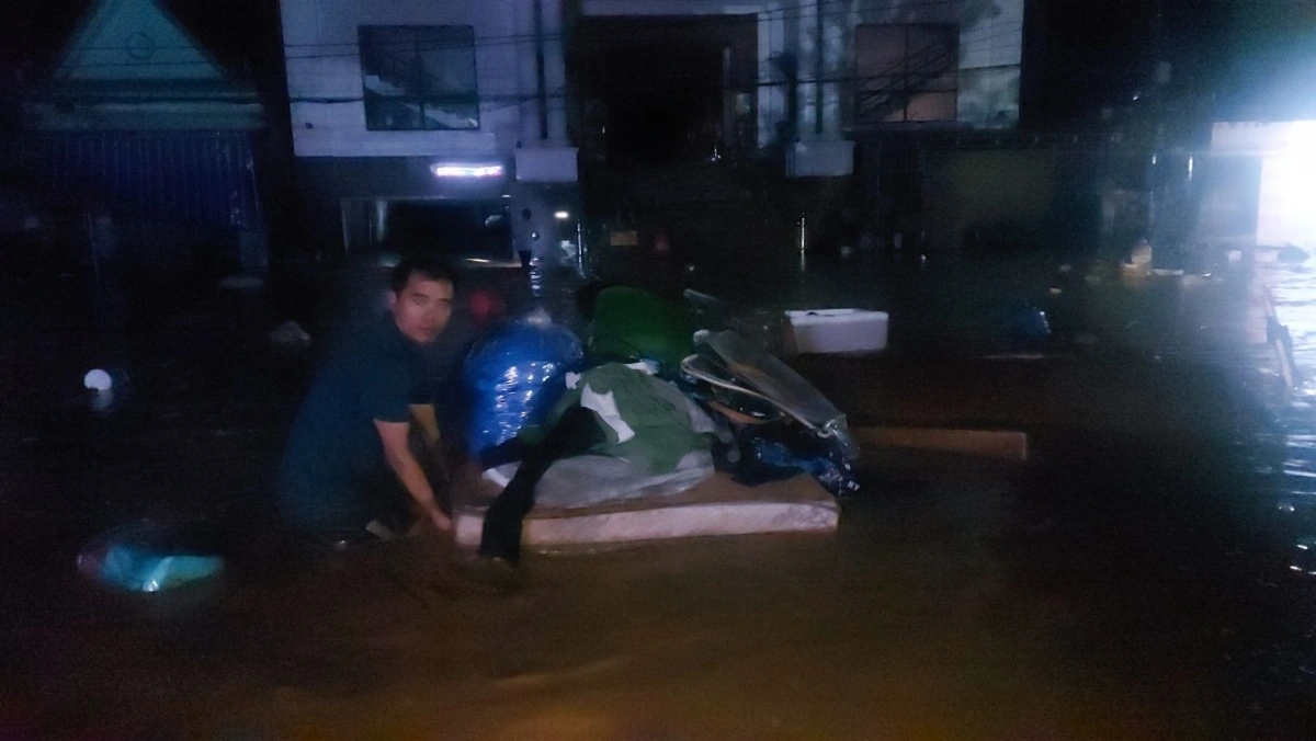 Người dân Mường Xén tạo các bè, lội bì bõm trong nước di tản đến nơi an toàn. (Ảnh: Đào Thọ)