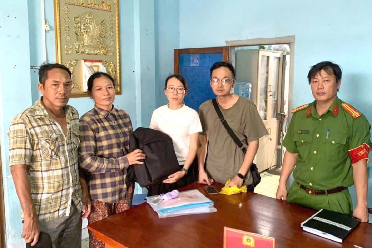 Chị Châu Thị Ngọc Lộc (áo caro đen) trao trả số vàng cho người bị mất - Ảnh: CALĐ