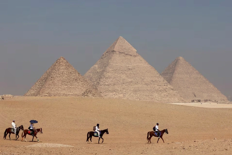 Khách du lịch cưỡi ngựa trước Kim tự tháp Giza, ngoại ô Cairo, Ai Cập. Ảnh: Reuters