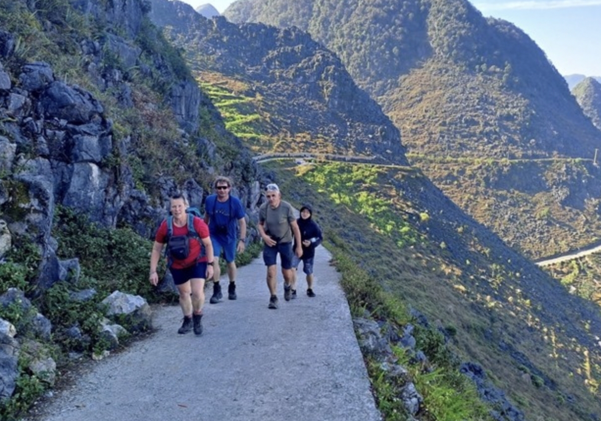 Foreign tourists explore the towering mountains of Pa Vi commune, Meo Vac district, in the northern mountainous province of Ha Giang (now part of Tuyen Quang province). (Photo: VNA)
