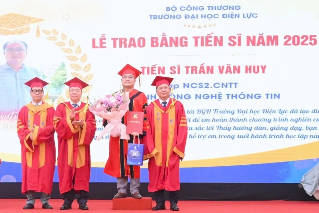 NGƯT.PGS.TS Vũ Đình Ngọ - Bí thư Đảng ủy, Chủ tịch Hội đồng Trường; PGS.TS Đinh Văn Châu - Phó Bí thư Đảng ủy, Hiệu trưởng Nhà trường tặng hoa và trao bằng cho các tân tiến sĩ. Ảnh: CTV