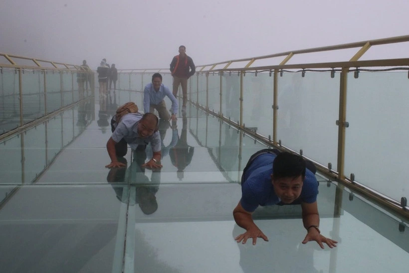 Tourists enjoy the experience of trying out various photo poses on Rong May glass bridge.