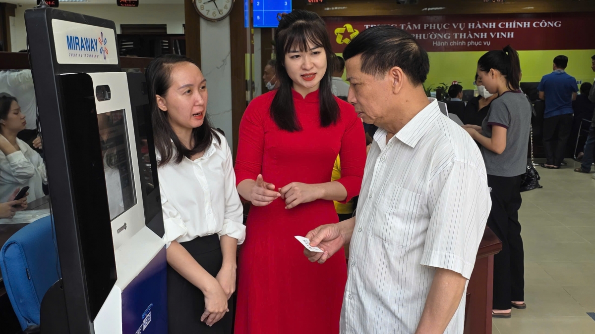Ông Phạm Đình Lan được cán bộ hướng dẫn làm thủ tục. Ảnh: Bá Thăng.