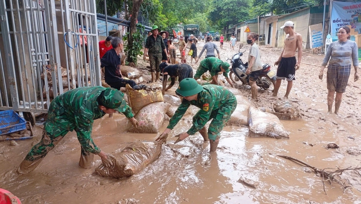 Bộ đội và dân bản cùng nhau xếp lại từng viên gạch, nhặt từng bao lúa còn sót lại. Cuộc sống bắt đầu lại từ chính những gì còn vớt vát được.