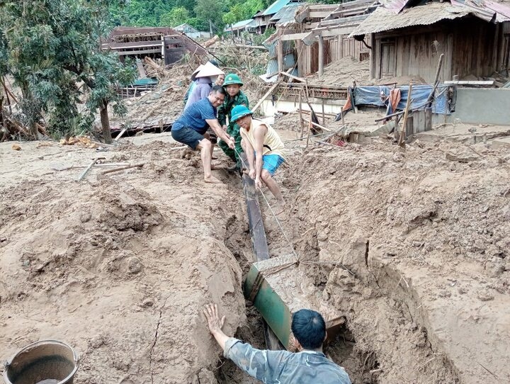 Đặt chân đến bản làng đổ nát đầu tiên, người lính không kịp nghỉ. Họ sẵn tay đào bùn, bới tìm đồ đạc bị chôn vùi.