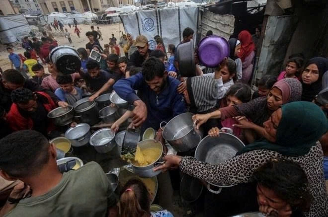 Người dân Palestine nhận thực phẩm miễn phí tại một trung tâm phân phối thực phẩm ở Thành phố Gaza, ngày 12/5/2025. Ảnh: Xinhua