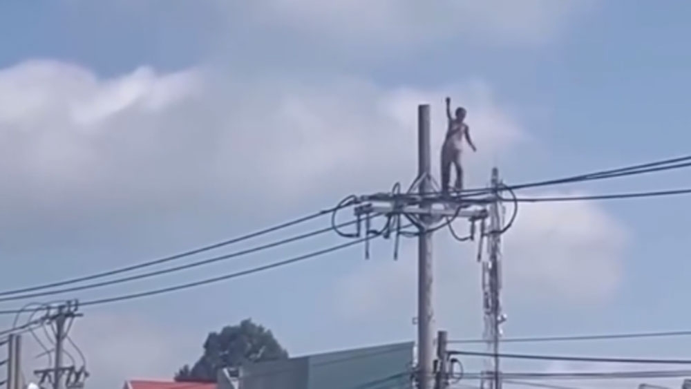 Người phụ nữ đứng trên trụ điện 