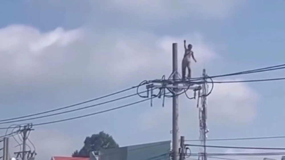 Bà Hào cố gắng bước đi trên dây điện. (ảnh cắt từ video chia sẻ MXH)