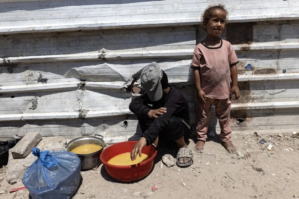 Hai em nhỏ đứng bên ngoài một bếp ăn từ thiện ở thành phố Gaza, ngày 23/7/2025. Ảnh: NY Times