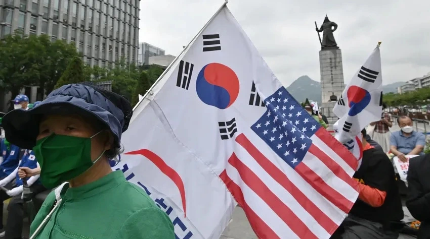 Một người dân cầm cờ Mỹ và Hàn Quốc tại Seoul (Hàn Quốc). Ảnh: AFP