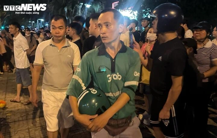 Sau khi đưa bé gái đi cấp cứu, anh Cương (mặc đồng phục Grab) trở lại hiện trường để xem có ai cần giúp đỡ nữa không. (Ảnh: Viên Minh)