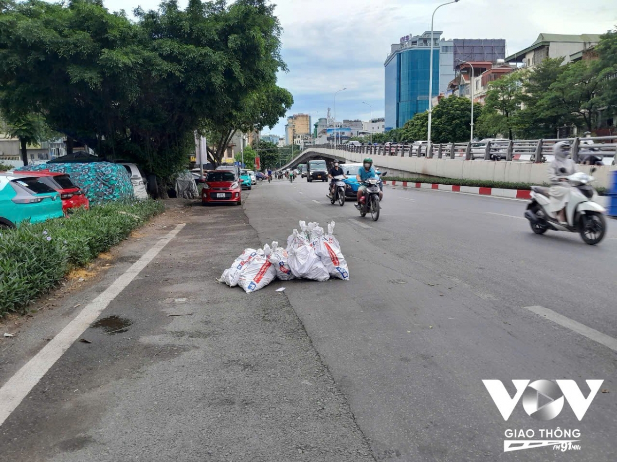 Hàng chục bao tải đựng phế thải xây dựng nằm ngổn ngang chiếm gần hết một làn đường phố Trần Khát Chân.