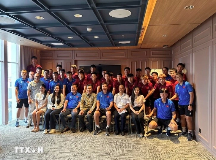 Ambassador Ta Van Thong (fourth, left, front row) staff of the Vietnamese Embassy, and the Vietnamese community in Indonesia pose for a group photo with the Vietnam U23 men's football team.