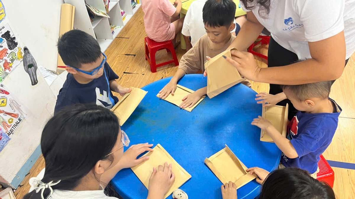 Trẻ em được thực hành gấp túi bằng bìa giấy