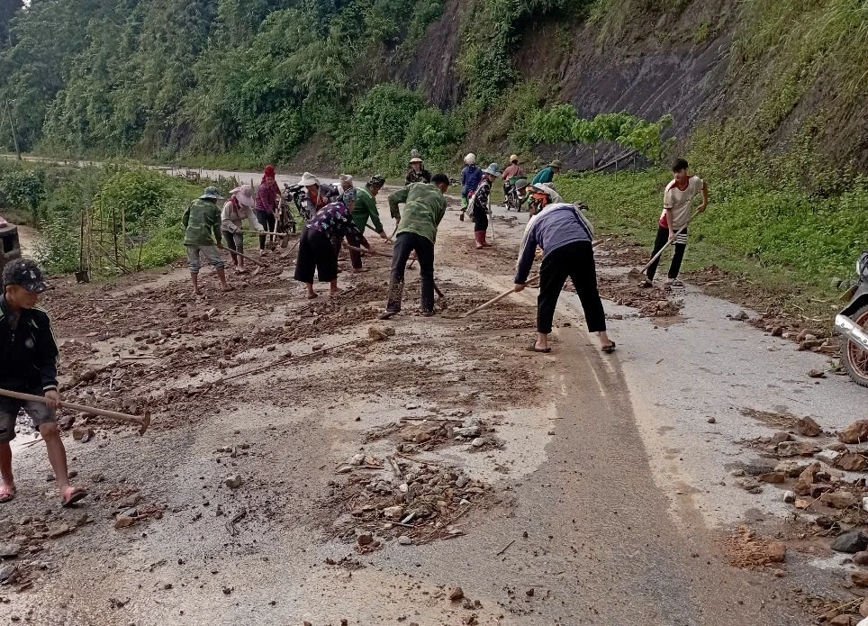 Các lực lượng chức năng, nhân dân tham gia khắc phục các đoạn đường bị sạt lở.