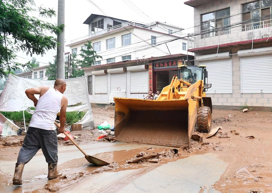 Người dân dọn dẹp sau mưa lũ ở Trung Quốc. Ảnh: Reuters