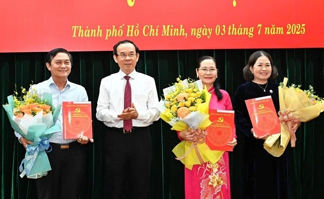 Ông Nguyễn Văn Nên trao Quyết định và hoa cho bà Nguyễn Thị Lệ, bà Nguyễn Thị Yến và ông Nguyễn Văn Lộc (ảnh Việt Dũng/SGGP)