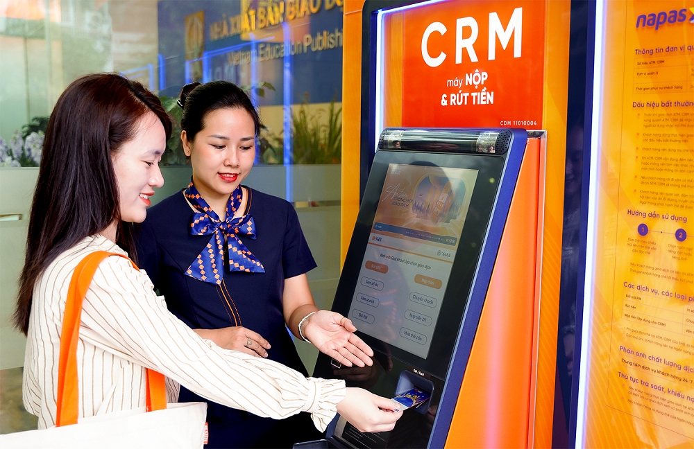 Giao dịch viên SHB hướng dẫn khách hàng sử dụng máy CRM