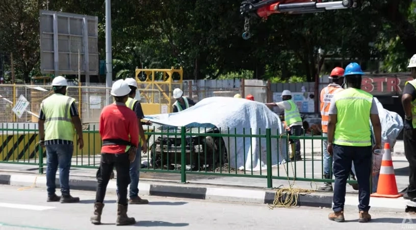 Chiếc xe được kéo lên khỏi hố "tử thần". Ảnh: CNA