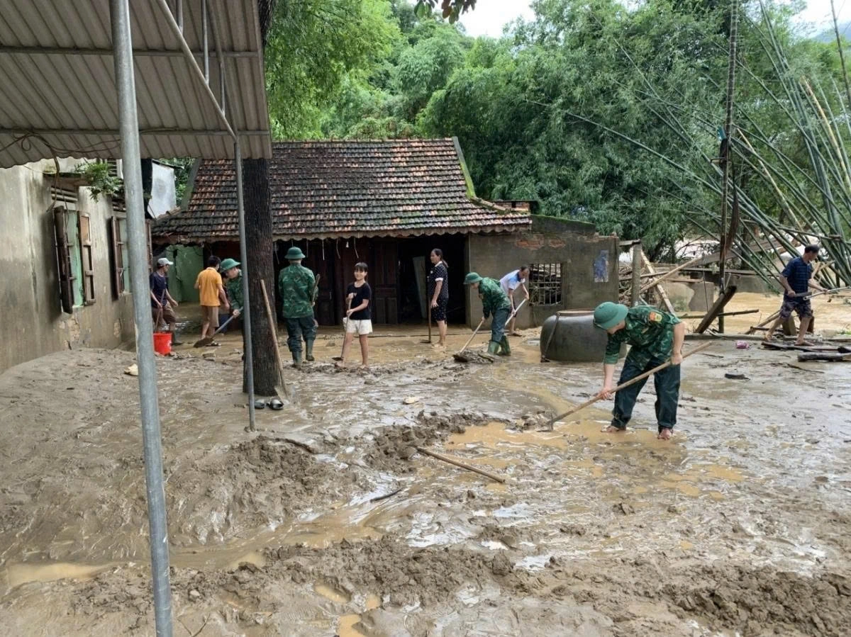 Soldiers clean up the mud alongside local residents as soon as the floodwaters recede.