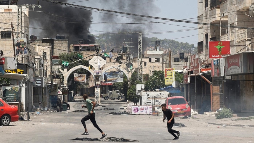 Người dân Palestine tìm chỗ trốn khi lực lượng Israel tấn công vào Bờ Tây. (Ảnh: Reuters)