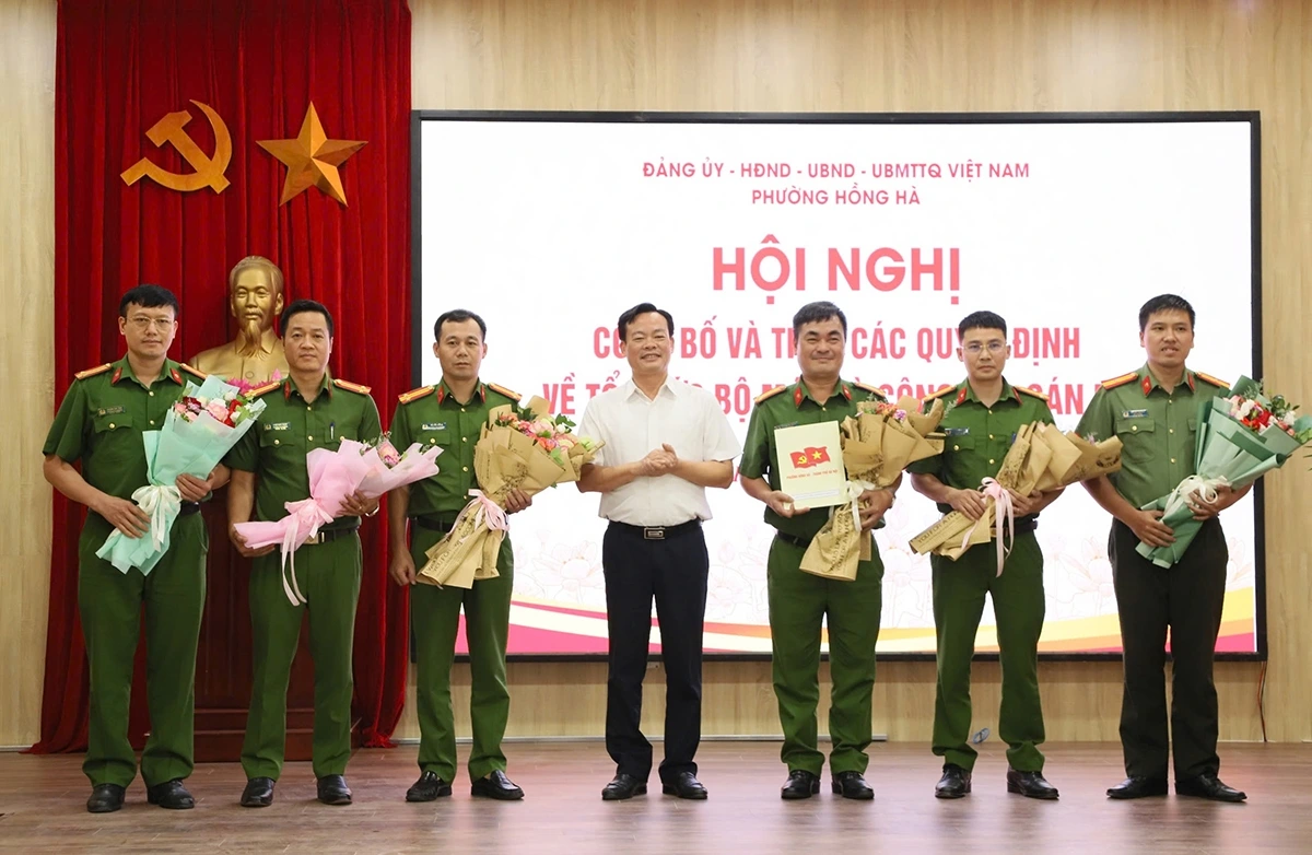 Bí thư phường Hồng Hà trao quyết định thành lập, bổ nhiệm của Bộ Công an, tặng hoa Trưởng Công an và các Phó trưởng Công an phường Hồng Hà. Ảnh: PV