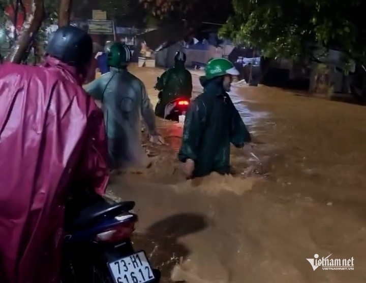 Tuyến đường Âu Cơ (phường Liên Chiểu) dòng nước đục chảy xiết, người dân không thể di chuyển phải dừng lại bên đường.