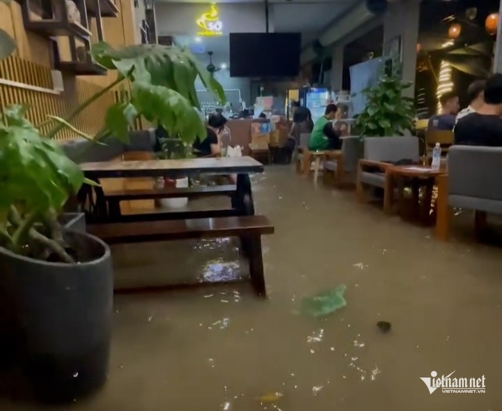 Nước tràn vào quán cà phê trên đường Ngô Văn Sở.