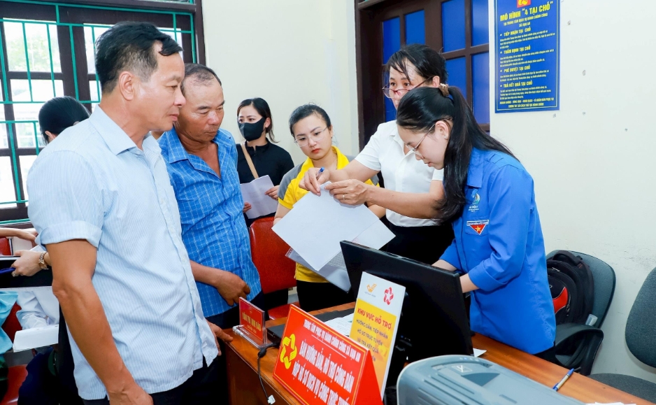 Cán bộ xã Vạn An hướng dẫn người dân làm thủ tục.